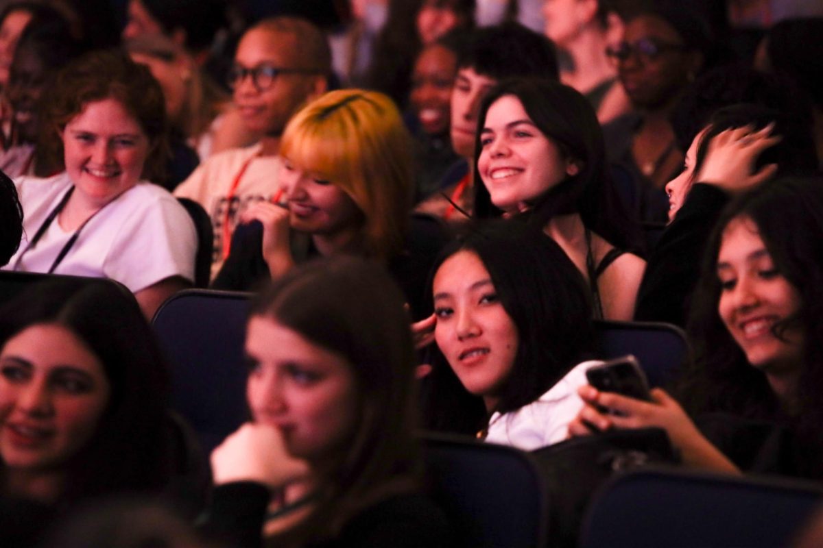 Laughing, communications senior Emily Bailly smiles as she watches the concert.
