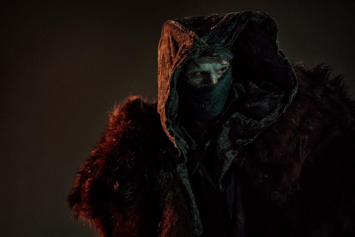 A shot of Jacob Elordi as the Creature, standing cloaked in the middle of the icy plains as he plots his final act of revenge against Victor. Photo taken from the official “Frankenstein” Website.