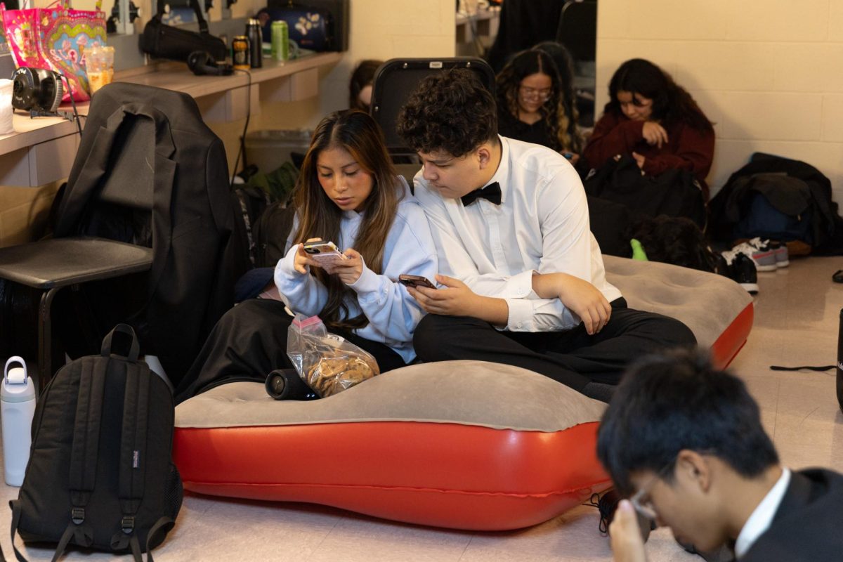 Sitting together on an inflatable mattress, band sophomores Adriana Lopez-Tzun and Anthony Vera wait in a backstage room to be called for their next performance. Students who participated in the Prism concert stayed in the Kravis center Dec. 2 from 8:30 a.m. to 1:00 p.m. for the daytime rehearsal. 