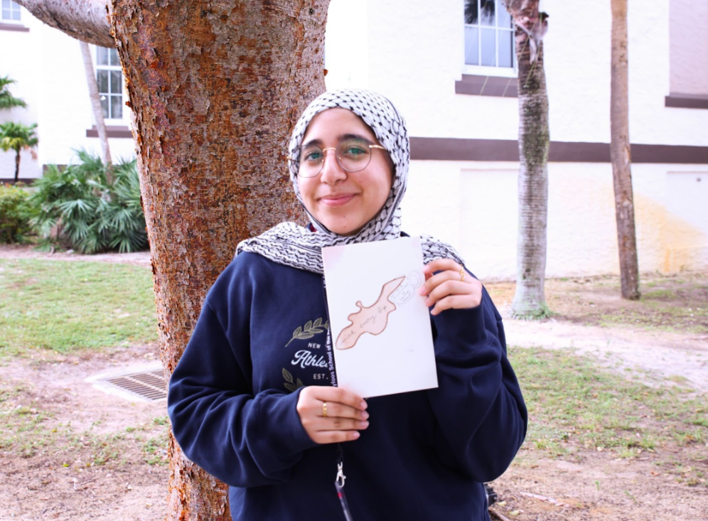 Posed headshot of communications senior Hanna Masudi, holding her published book, “With every sip.” “I feel like when you think of poetry, you think of complicated things,” Masudi said. “But poetry isn’t meant to make simple concepts complicated. It’s meant to make complicated emotions simple.”