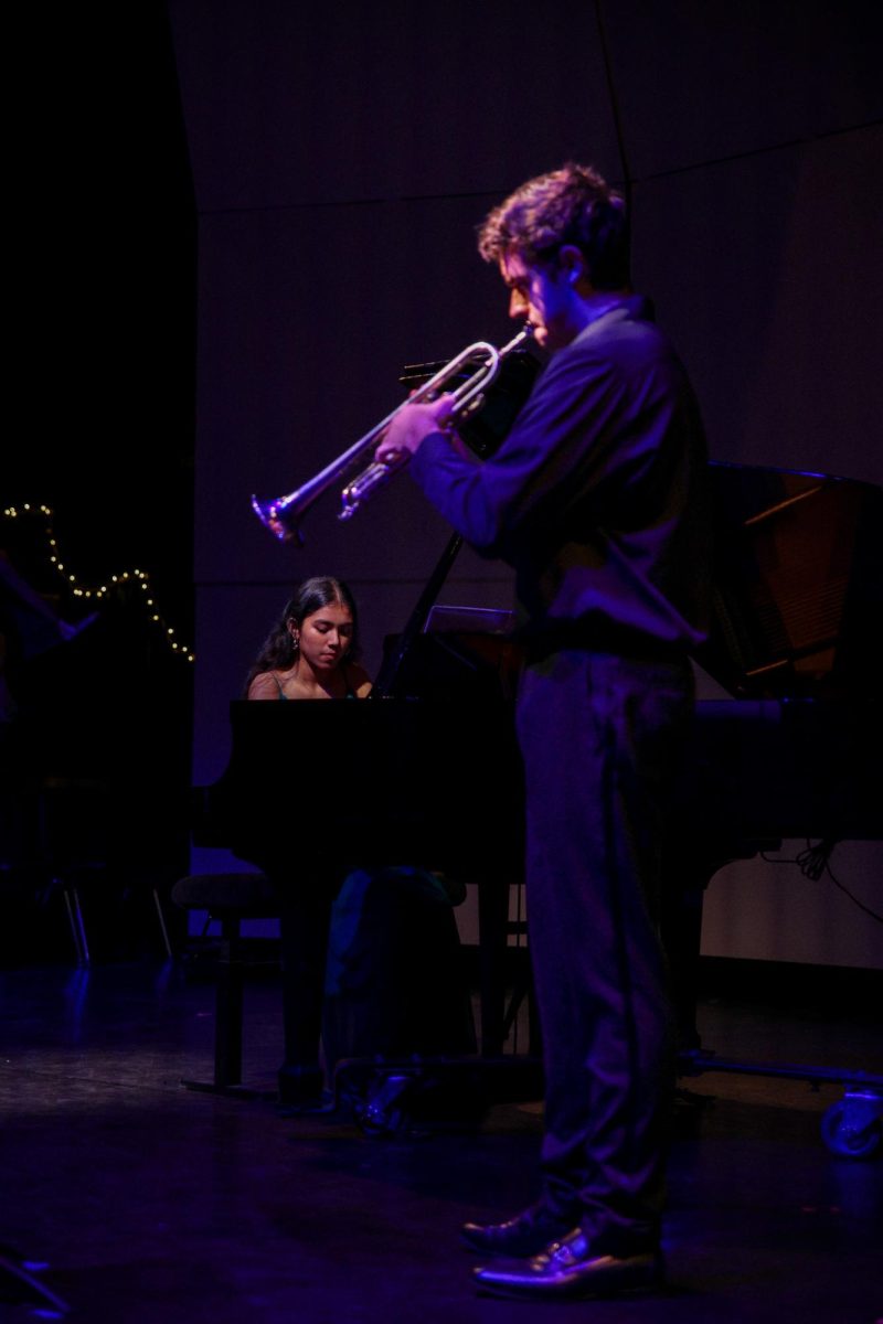 Playing the trumpet, band senior Jackson Murray performs a duet of Alexander Goedicke’s "Concert Etude Op. 49” with piano junior Eva Basnet. During their performance, pianists were able to have musicians of other instruments accompany them, such as the violin and trumpet.