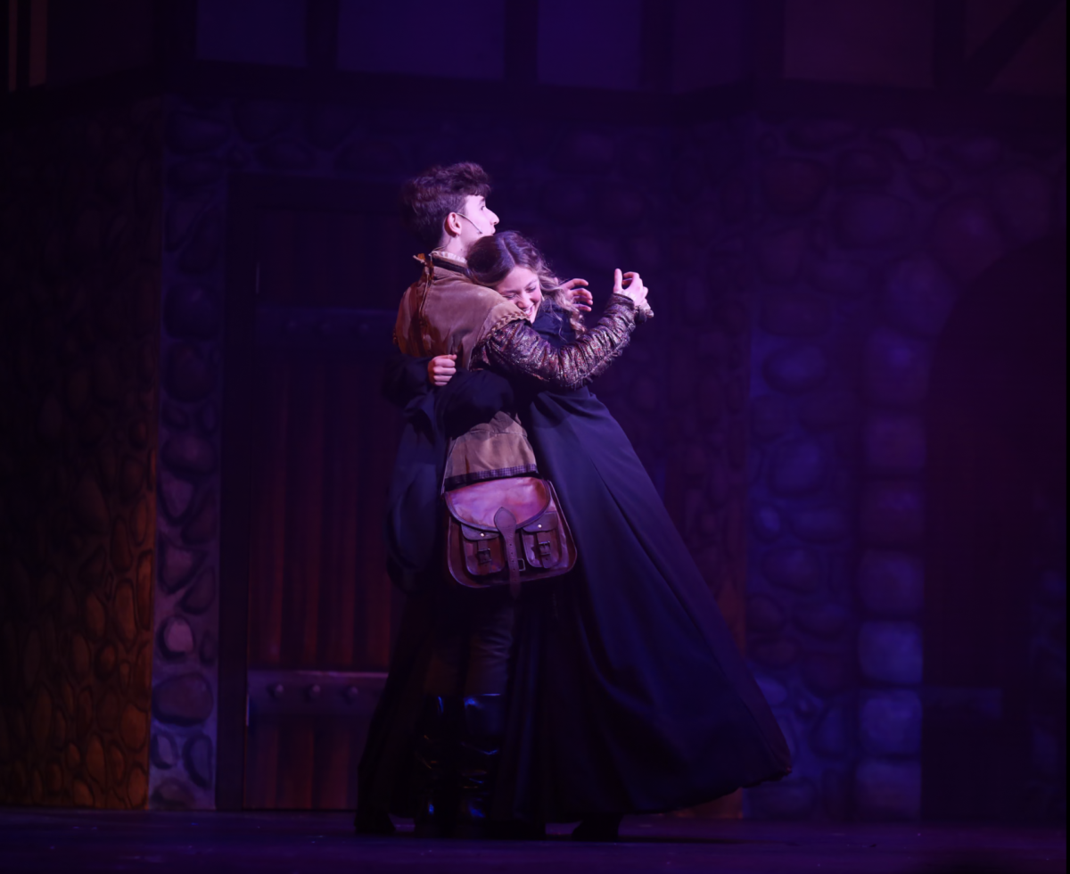 Hugging theatre sophomore Chase Bauer (Nigel Bottom), theatre sophomore Kayla Brown (Portia), daughter of a Puritan, performs their duo, “I Love the Way.” 