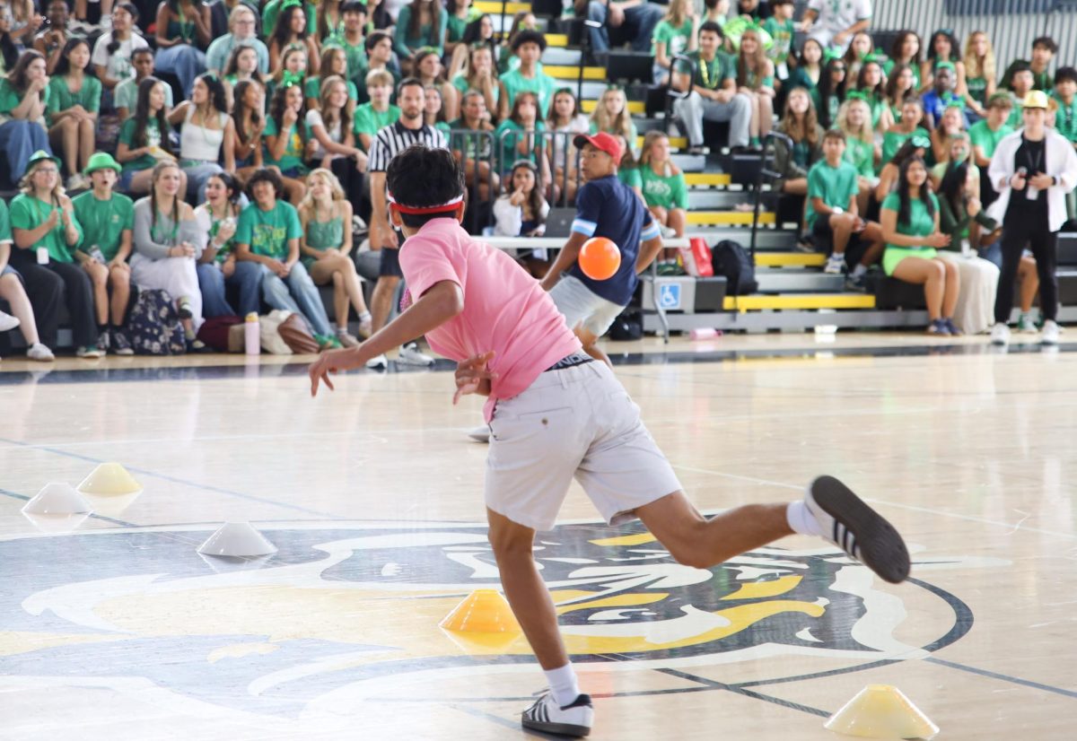 Throwing a dodgeball toward his opposing freshman competition, visual junior Max Cannon hits one of the freshmen with a dodgeball to get them out.