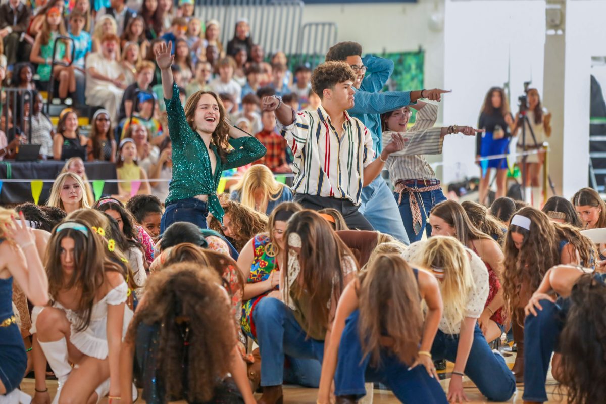 Pointing out toward the crowd, theatre junior Enrique Parisca, theatre junior Richard Moore, and visual junior Marcalix Lemene perform in the junior class’ Generations dance, representing the ‘70s and dancing to the song “Boogie Wonderland” by the band Earth, Wind & Fire.