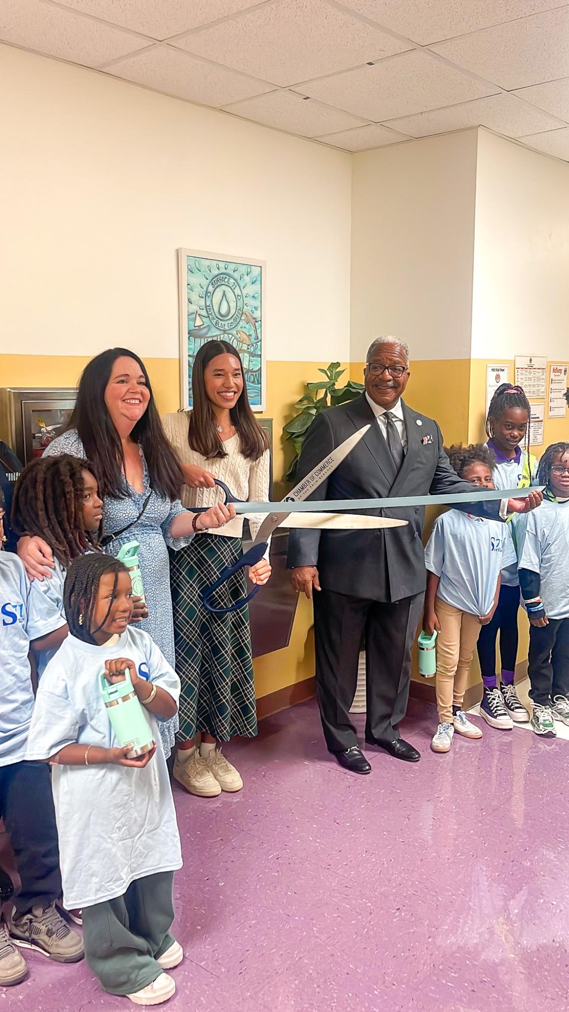 Cutting the ribbon, president of Surface 71 and communications junior Lyra Radashkevich  officially opened a water filling station for Pleasant City Elementary Nov. 13, 2025. Surface 71 is an environmental conservation organization. Photo courtesy of Lyra Radashkevich
