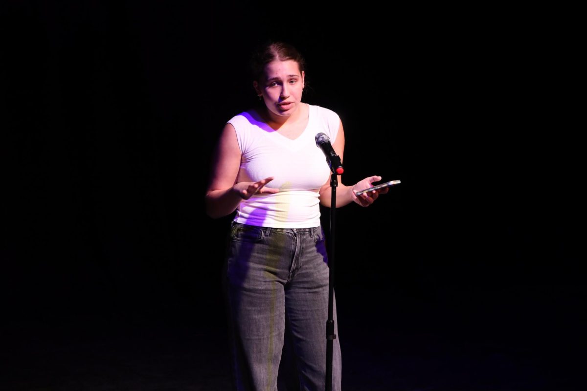 Introducing the first annual “Slam Jam,” a fundraising performance for the Slam Poetry team, communications junior Maya Bourak opens with a speech explaining the event. The event,  held in the Brandt Black Box Theater, was a mock competition with English teachers, who played judges, with scoreboards of 0 to 10 for rankings. 