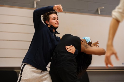 Supporting theatre junior Karma Carr as they lean back into his arms, theatre sophomore Saiden Tamim watches Whitacre as she walks them through the choreography for “Dentist!”