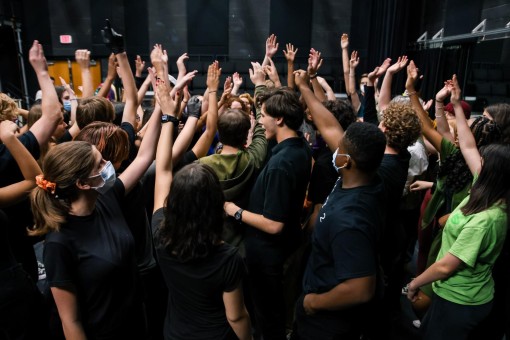 Preparing for the show, the cast and crew throws their hands up as they call out “Little Shop of Horrors.”