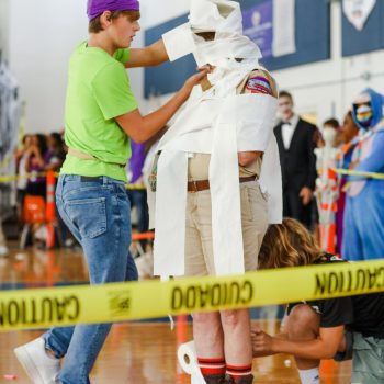 Wrapping English teacher Martha Warwick in toilet paper, vocal freshman Beau McDowell tries to cover her up as quickly as possible during the Fall Festival. The Fall Festival took place on Oct. 31 during lunch where all of the classes competed against each other through various games and activities.