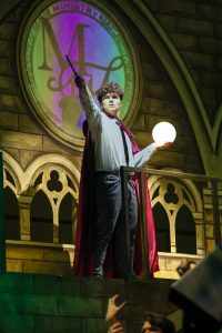 Pointing his wand out in one hand and holding an orb of light in the other, theatre junior Richard Moore enacts a statue. This scene depicted the students and professors’ search efforts to find Scorpius Malfoy and Albus Potter when they never made it to Hogwarts after using a Time-Turner.