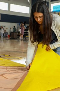 Cutting her “Kung-Fu Panda” themed senior banner, visual senior Maya Koppada assists in Fall Festival preparation as the recording secretary of the senior class council. “I planned out our banner painting, and we all worked together to paint it over the span of two weeks,” Koppada said.