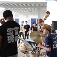 Counting down to begin their next song, band senior Van Grzybek leads the quintet’s tempo, signaling other elements of the band — including the piano, trumpet, saxophone, and cello — to begin.