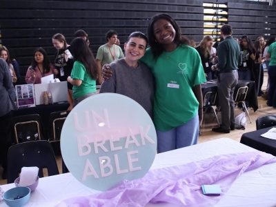 Theatre sophomore and sophomore class council representative Kayla Ledger and founder of the
Unbreakable Society Brittany Sinitch pose for a photo next to their sign. The Unbreakable
Society's main goal is to reduce the stigma surrounding victims of gun violence, providing
support, and building a future where mental health is valued.
