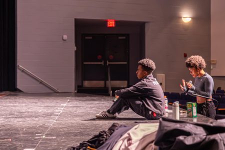 Evaluating actors' feet movements during a tap-dance scene, student choreographer assistant and theatre senior Kevontay Oliver listens as the performers sing a number from the musical, “Something Rotten.” The student choreographer provides feedback regarding the actors’ coordination and movement on stage.