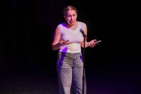 Introducing the first annual “Slam Jam,” a fundraising performance for the Slam Poetry team, communications junior Maya Bourak opens with a speech explaining the event. The event, held in the Brandt Black Box Theater, was a mock competition with English teachers, who played judges, with scoreboards of 0 to 10 for rankings.
