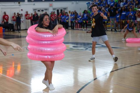 Covered in a stack of inflatable pool rings, band senior Princess Leyson runs back to the finish line in “Inflatable Tower.” The senior class won first place in this game during the Pep Rally.